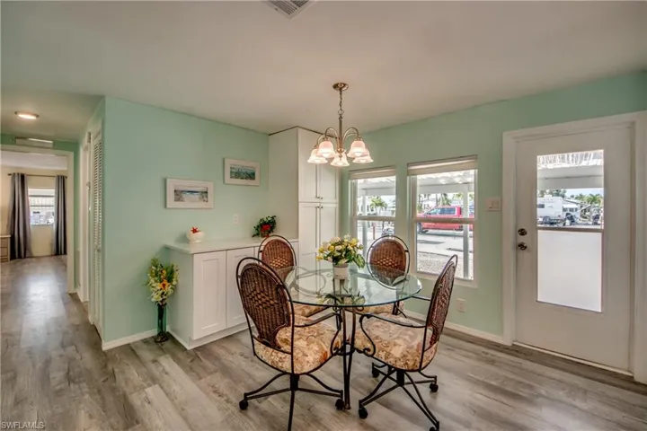 Dining room with a chandelier, light wood-style floors, and healthy amount of natural light