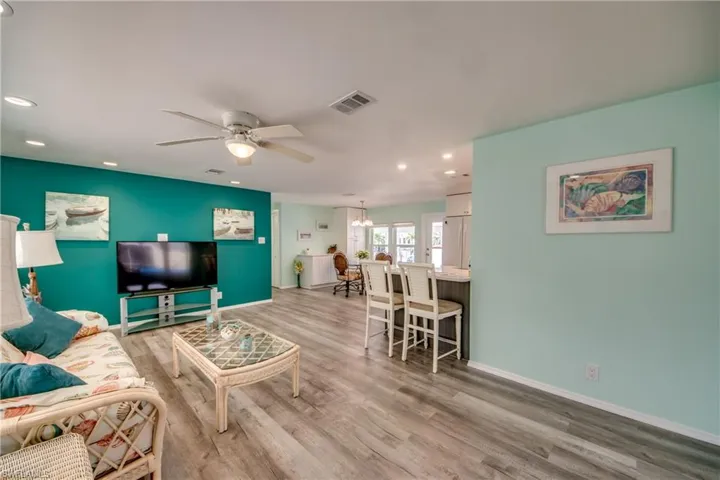 Living room featuring a ceiling fan, light wood-type flooring, and recessed lighting