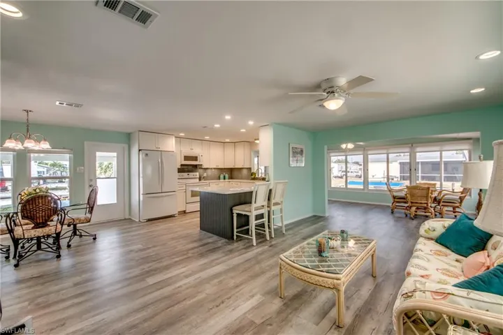 Living area with recessed lighting, ceiling fan, light wood-type flooring, and a chandelier