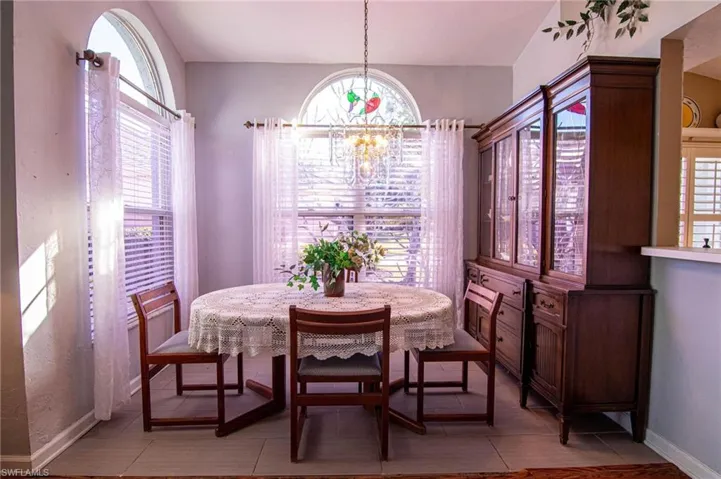 Tiled dining area featuring an inviting chandelier