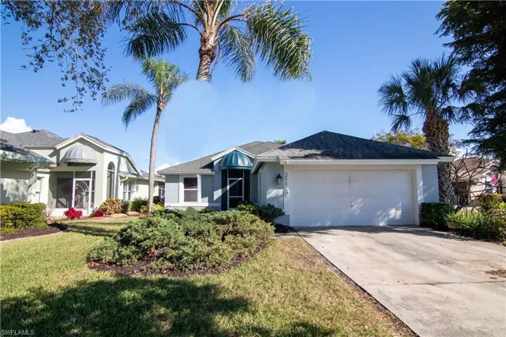 Ranch-style home with a front lawn and a garage