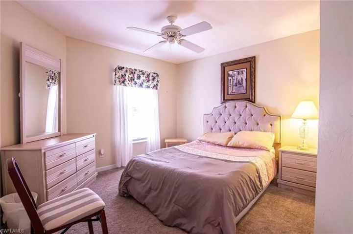 Carpeted bedroom featuring ceiling fan
