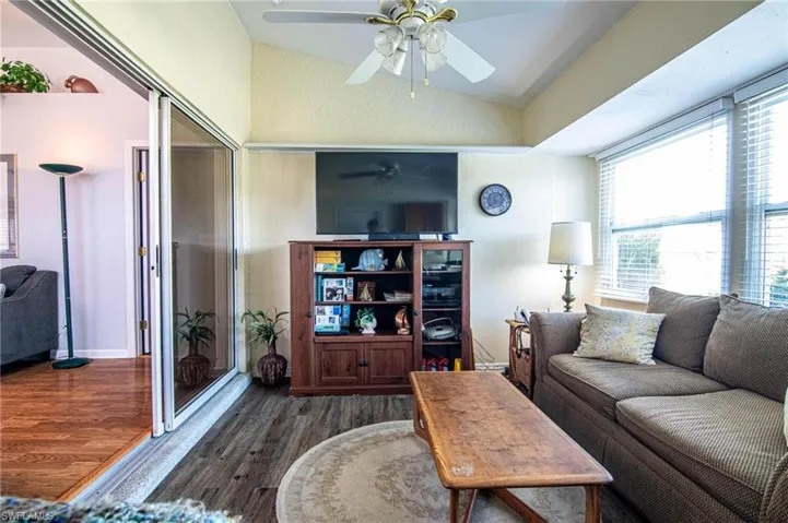 Living room with vaulted ceiling and dark wood-type flooring
