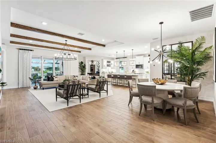 Dining space with beam ceiling, light wood-type flooring, and an inviting chandelier