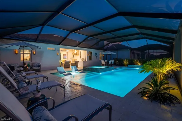 View of pool with glass enclosure, an outdoor living space, an in ground hot tub, and a patio