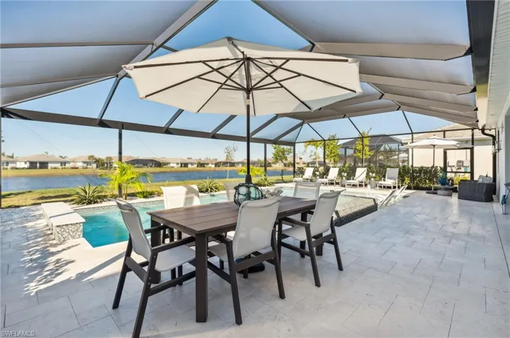 View of patio featuring a lanai and a water view