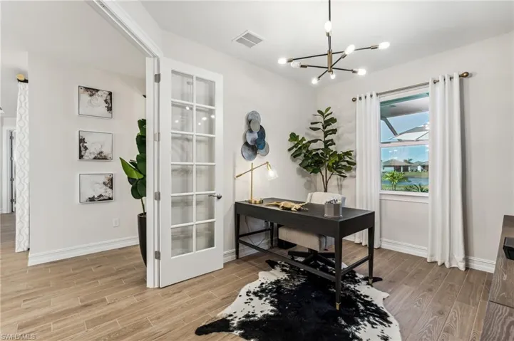 Office space featuring a chandelier and light hardwood / wood-style flooring