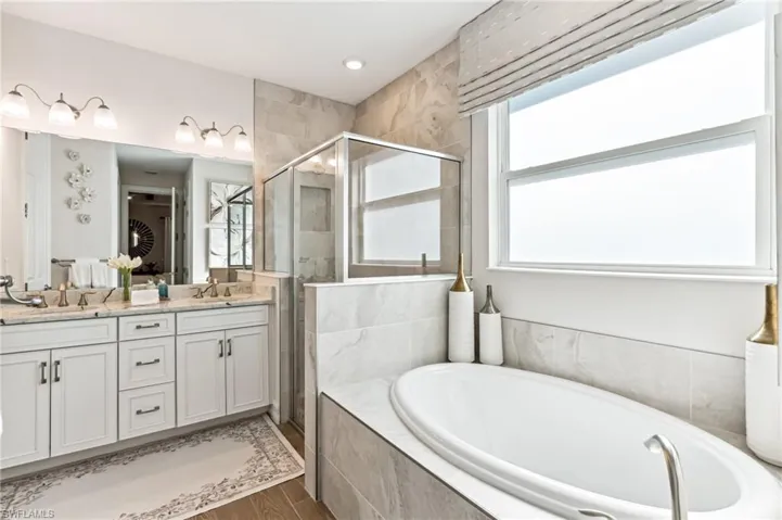 Bathroom with vanity, wood-type flooring, and independent shower and bath