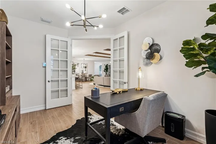 Office featuring french doors, an inviting chandelier, and wood-type flooring