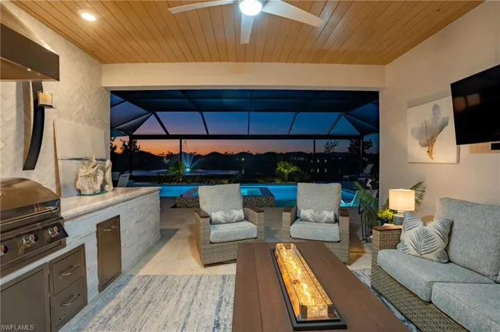 View of patio / terrace featuring area for grilling, glass enclosure, grilling area, and an outdoor fire pit