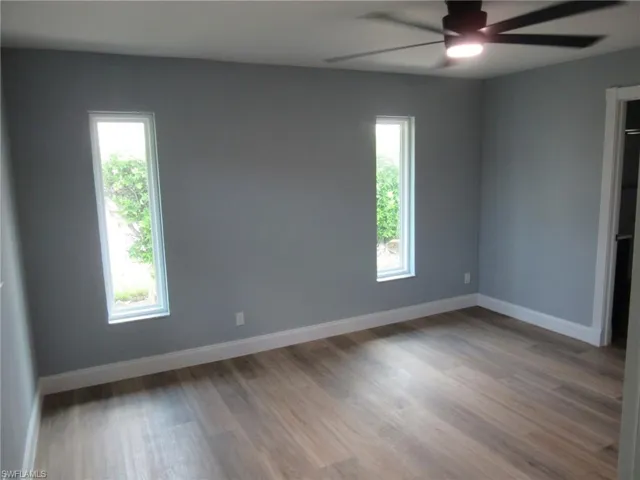 Unfurnished room featuring light wood finished floors, healthy amount of natural light, and ceiling fan