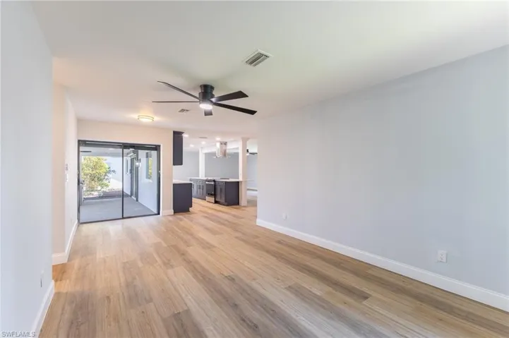 Unfurnished living room featuring light wood-type flooring and a ceiling fan