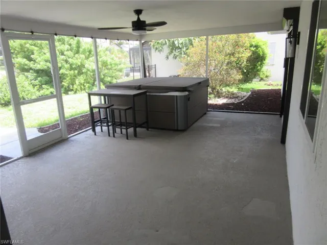 Sunroom with a ceiling fan and a jacuzzi