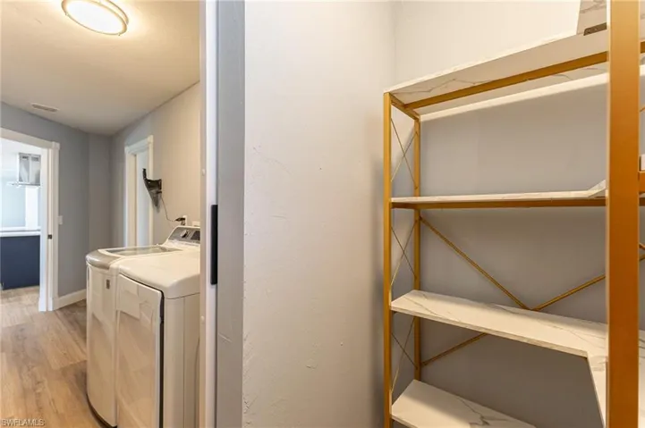 Laundry area featuring light wood-type flooring and washer and dryer