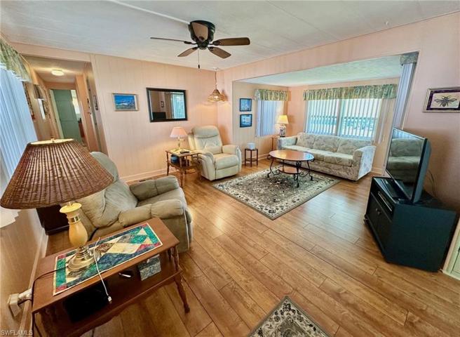Spacious living room with laminate floors and ceiling fan.