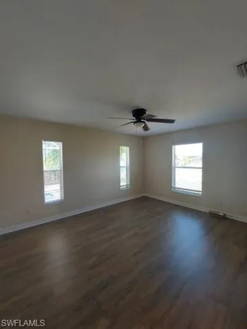 Unfurnished room with dark wood-type flooring