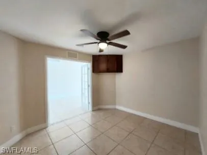 Unfurnished room with light tile patterned flooring and a ceiling fan