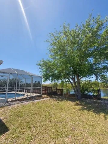 View of yard with glass enclosure, a sunroom, and a patio area