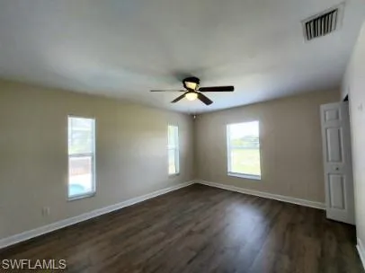 Unfurnished bedroom featuring dark wood-style flooring and ceiling fan
