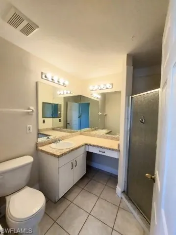 Bathroom featuring a shower stall, vanity, and light tile patterned floors