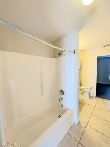 Bathroom with light tile patterned floors and shower / bathtub combination