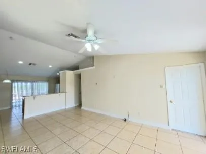 Unfurnished room with vaulted ceiling, ceiling fan, and light tile patterned flooring
