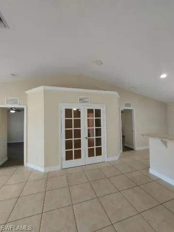 Empty room with light tile patterned floors, vaulted ceiling, french doors, and recessed lighting