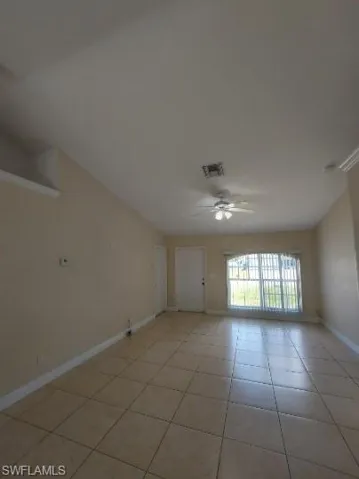 Empty room featuring ceiling fan and light tile patterned floors