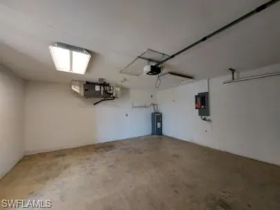 Garage featuring water heater and electric panel