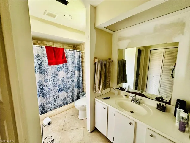 Bathroom featuring vanity, tile patterned flooring, and toilet