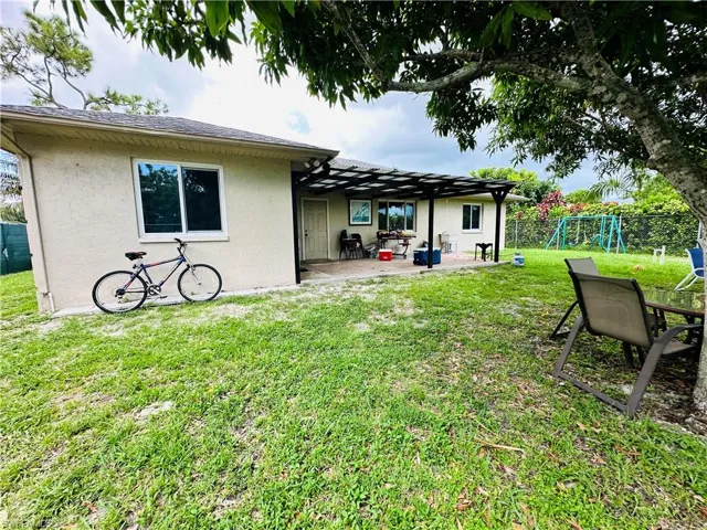 Back of property with a yard and a patio area