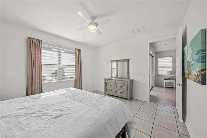Bedroom with light tile patterned floors and ceiling fan