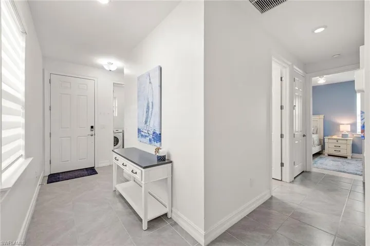 Corridor featuring light tile patterned flooring, recessed lighting, and washer / clothes dryer