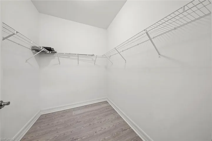 Walk in closet with light wood-style flooring
