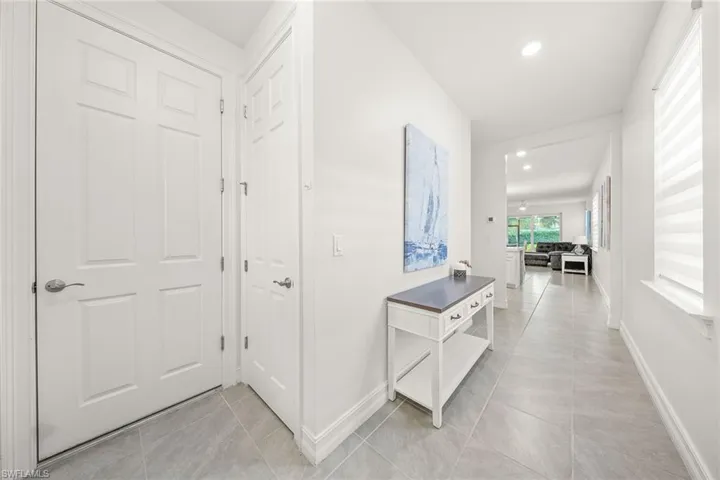 Corridor with light tile patterned floors and recessed lighting