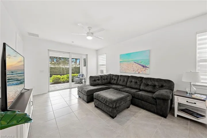 Living area with a ceiling fan and light tile patterned floors