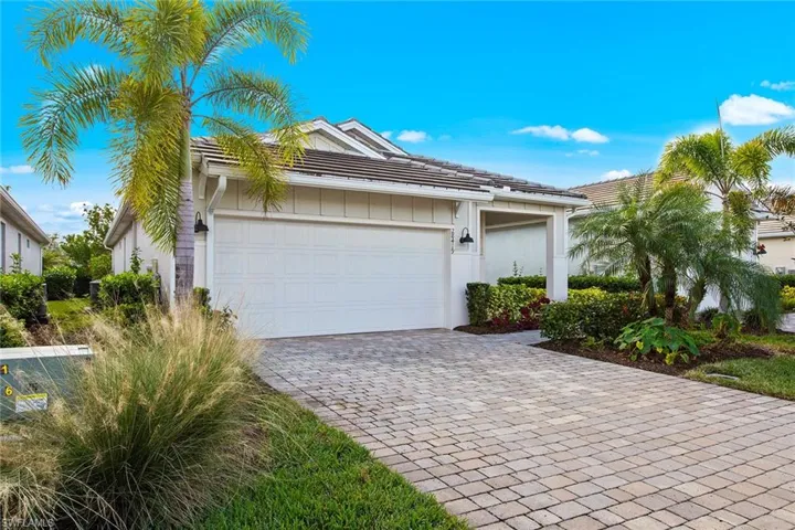 View of front of property with decorative driveway, a tile roof, an attached garage, and stucco siding