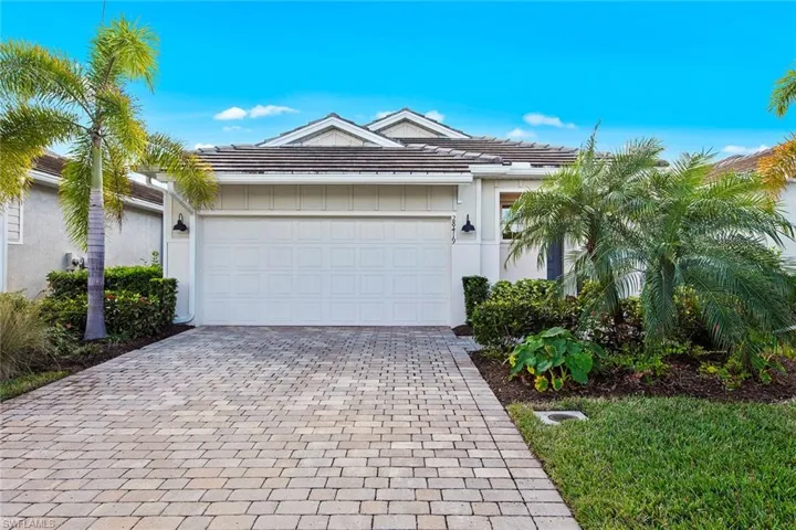 Single story home featuring decorative driveway, a garage, and board and batten siding