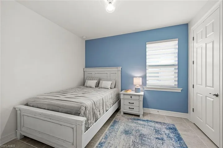 Bedroom with light tile patterned floors and baseboards