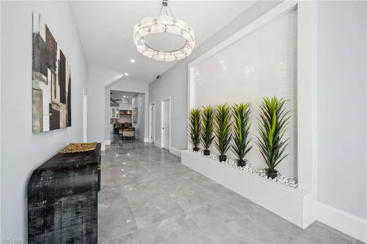 View of the foyer with shiny tile floors, high ceilings and modern touches
