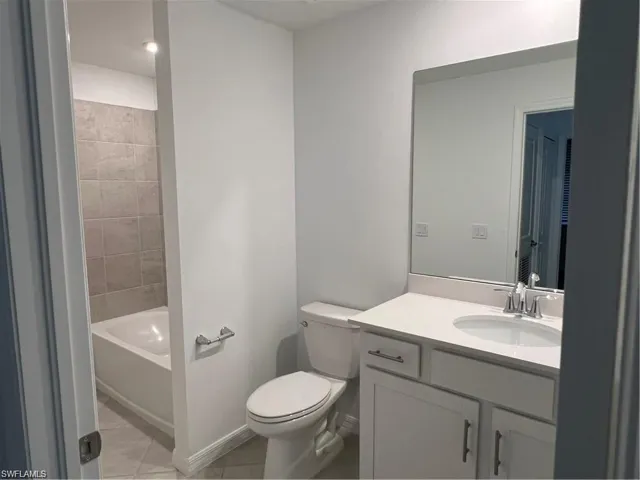 Full bath with vanity and light tile patterned floors