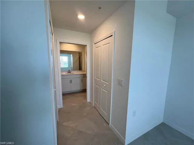 Hallway featuring baseboards and light tile patterned floors