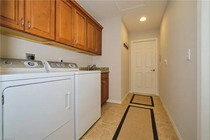 Laundry room with wash tub and extra wood cabinets.