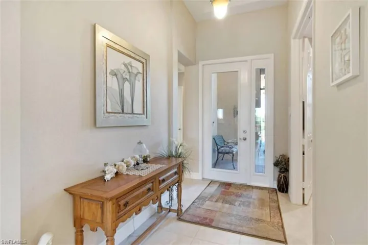 View of tiled entrance foyer with glass doors that let in lots of natural light