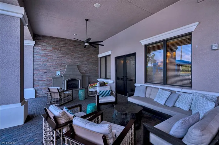 View of clubhouse patio featuring an outdoor living space with a fireplace and ceiling fan