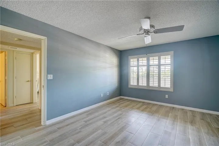 Spare room featuring ceiling fan, light hardwood / wood-style flooring, and a textured ceiling