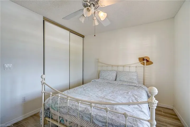 Bedroom featuring ceiling fan, a closet, a textured ceiling, and wood-type flooring
