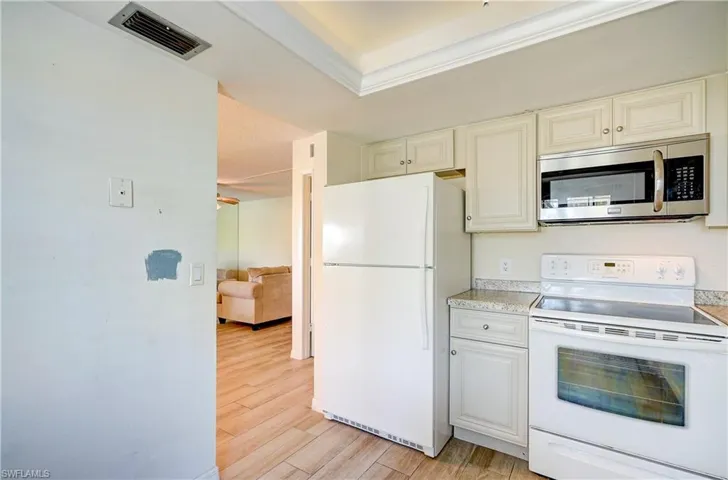 Kitchen with white appliances and light hardwood / wood-style floors