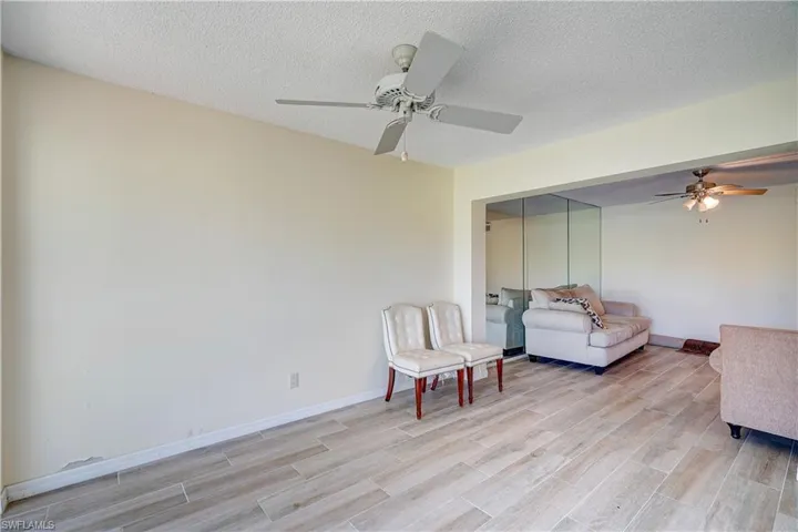 Sitting room featuring ceiling fan, light hardwood / wood-style floors, and a textured ceiling