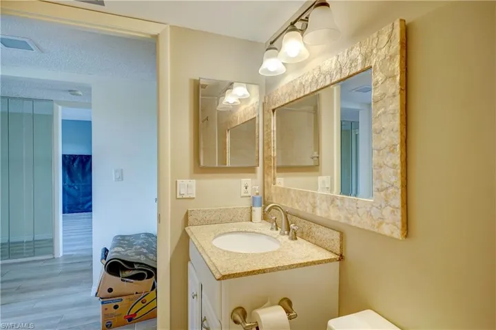 Bathroom with hardwood / wood-style floors, toilet, a textured ceiling, and large vanity